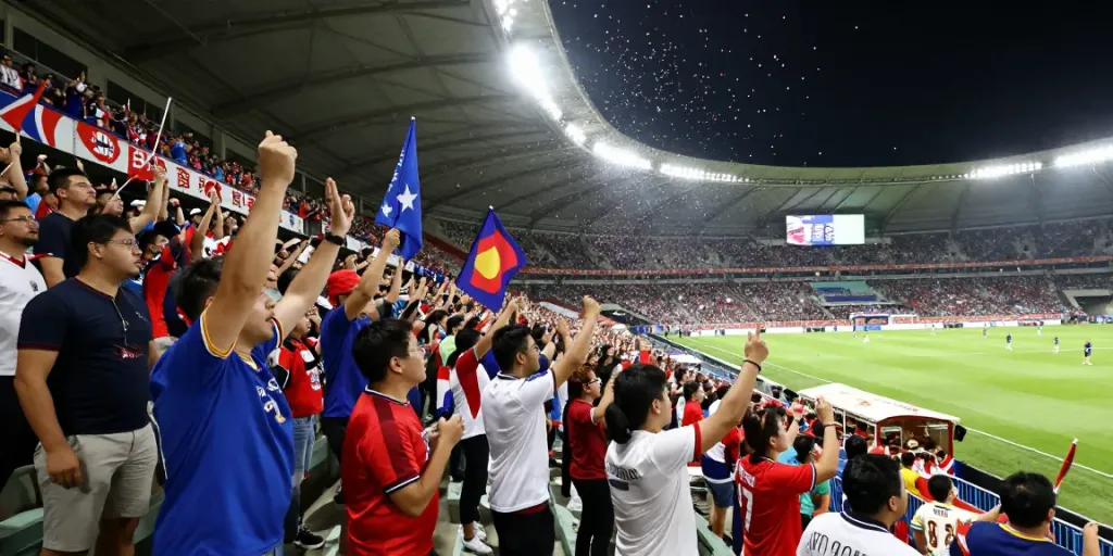 Excited fans enjoying a live match at tebakskor889.org football stadium.